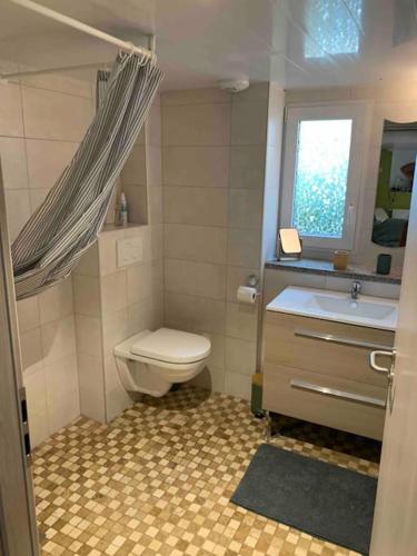 une salle de bain avec toilettes, lavabo et fenêtre dans l'établissement La Fromagerie de La Tourelle, à Sainte-Marie-aux-Mines