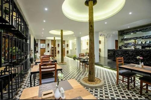 un restaurante con mesas y sillas en una habitación en Tushita Villa, Pool & Gardens, en Siem Reap
