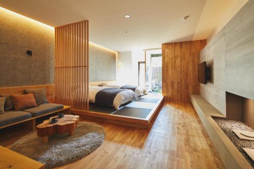 een slaapkamer met een bed, een bank en een tv bij Seirakuen in Atsugi