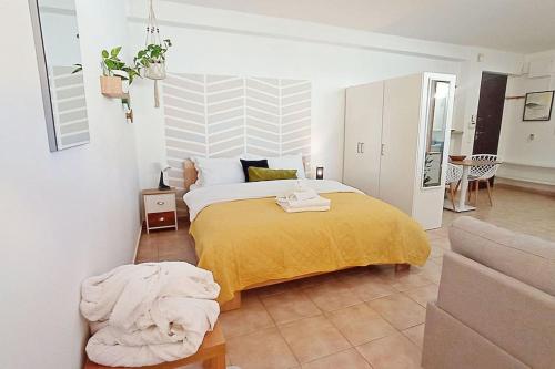 una camera con un letto con una coperta gialla di Relaxing Studio Apt, 1 min to Highway, Parking ad Atene
