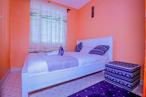 a bedroom with a white bed and a window at Fifi's in Kitui