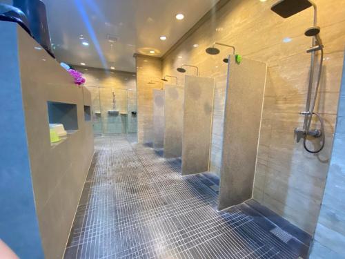 uma casa de banho com uma fila de cabinas de duche na casa de banho em On Hotel em Fort Stotsenburg