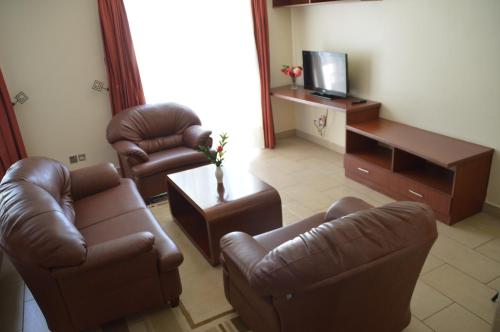 a living room with leather chairs and a television at Norfolk Towers Serviced Apartment -Nairobi, City Centre CBD in Nairobi