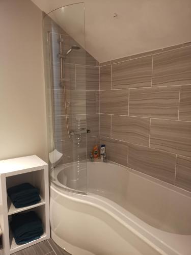 a bathroom with a white tub and a shower at Central Derby pride park 4 bedrooms 7 beds -Spacious contractors large group -Cul de Sac EasyFREE PARKING in Derby