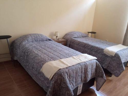 duas camas num quarto de hotel com duas camas sidx sidx em Paiva em Lima