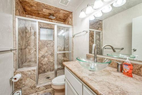 a bathroom with a glass bowl sink and a shower at Renovated home minutes from Fresno State / Airport in Fresno