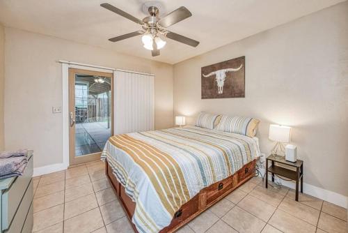 a bedroom with a bed and a ceiling fan at Renovated home minutes from Fresno State / Airport in Fresno