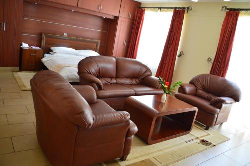 a living room with two chairs and a bed at Norfolk Towers Apartment in Nairobi