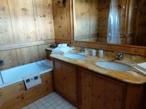 y baño de madera con 2 lavabos y bañera. en Ca' Myosotis, en Cortina dʼAmpezzo