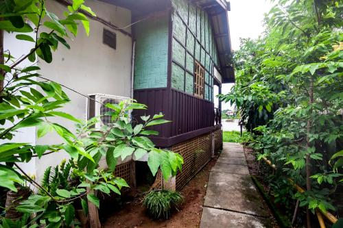 a house with a porch with a fence and plants at Lao Long Riverside and Budget Garden Guesthouse in Ban Khon