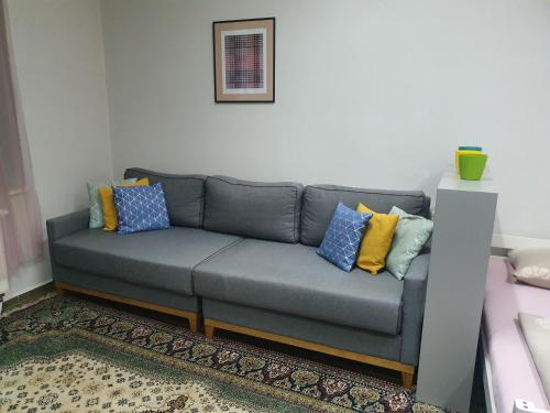 un sofá gris con almohadas coloridas en la sala de estar en OLD TOWN Sarajevo center apartment 2+2, en Sarajevo