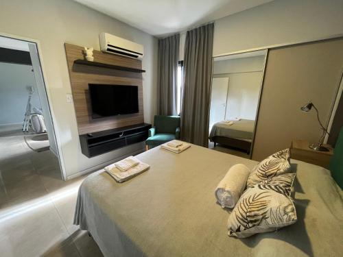ein Hotelzimmer mit einem Bett und einem TV in der Unterkunft Hermoso departamento en Yerba Buena in San Miguel de Tucumán