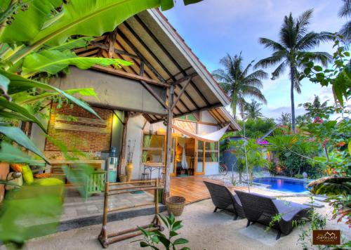 a house with a pool and a table and chairs at Villas SAMALAMA Gili Air in Gili Air