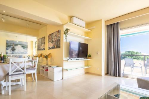 a living room with a television and a dining room at Marbella Este Next Marriott and Nikki B - Happy Rentals in Marbella