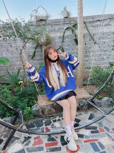 a girl is sitting on a swing at Ninh Binh Royal Homestay in Ninh Binh