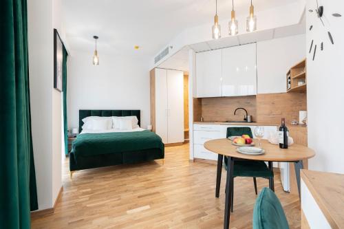 een keuken en een slaapkamer met een tafel en een bed bij Apartamenty Wola Tower in Warschau