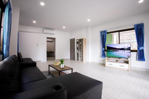 a living room with a couch and a flat screen tv at Grand View Premium in Patong Beach
