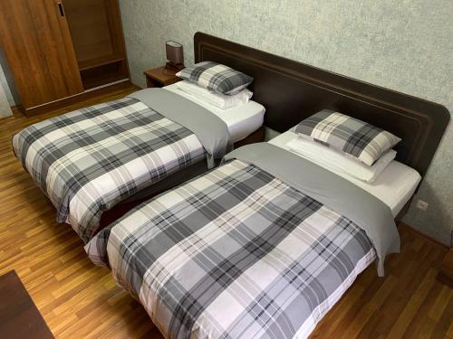 two beds sitting next to each other in a room at Cinzano Complex in Samarkand