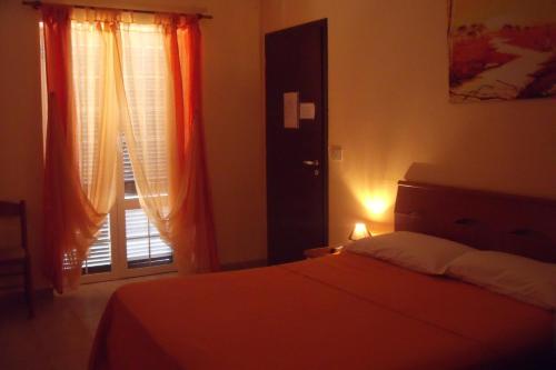 a bedroom with a bed and a window with curtains at Sabrina Airport in Fiumicino