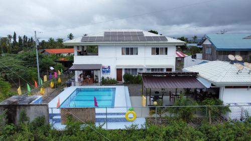 a house with a swimming pool in front of a house at Bernis Hostel in Moalboal