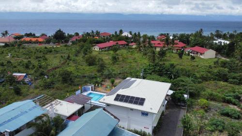 a group of houses on a hill next to the ocean at Bernis Hostel in Moalboal