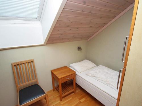a small bedroom with a bed and a chair at Five-Bedroom Holiday home in Jelsa 3 in Jelsa