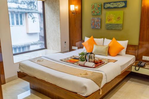 コルカタにあるMeraki Inn Saltlakeのベッドルーム1室(ベッド1台、食料品のトレイ付)