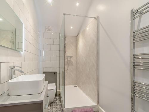 a bathroom with a shower and a sink and a toilet at The Cottage in Langsett