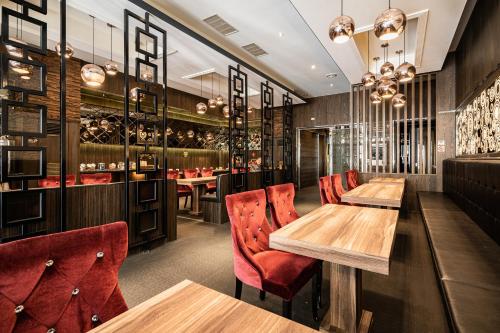 un restaurante con mesas de madera y sillas rojas en Global Traveler Hotel, en Kaohsiung