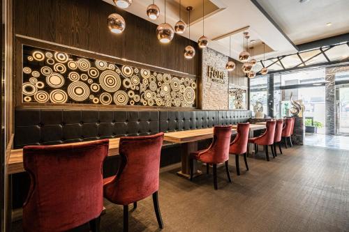a restaurant with a long table and red chairs at Global Traveler Hotel in Kaohsiung