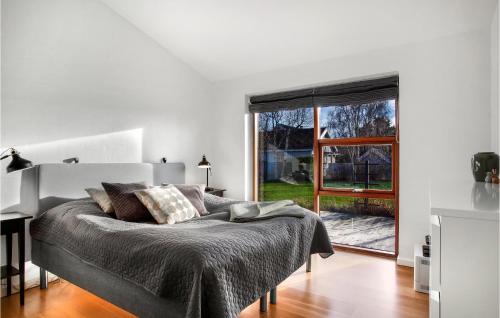 ein Schlafzimmer mit einem Bett und einem großen Fenster in der Unterkunft Beautiful Home In lbk With Wifi in Ålbæk