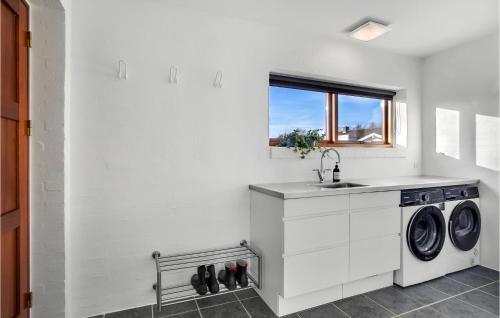 eine weiße Küche mit einem Waschbecken und einer Waschmaschine in der Unterkunft Beautiful Home In lbk With Wifi in Ålbæk