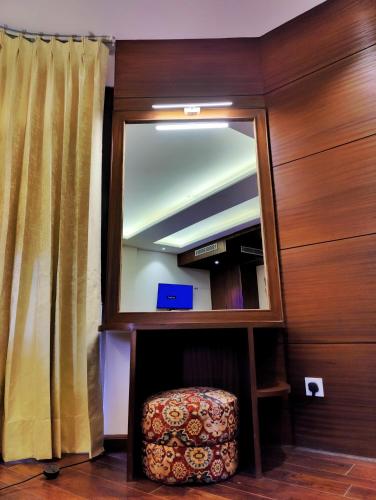 a mirror and a ottoman in a room at Royale Retreat Hotel & Spa Near Mall Road in Shimla