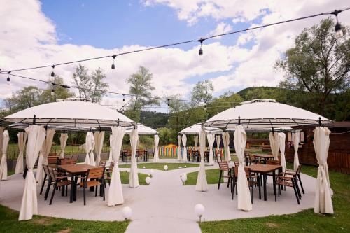 an outdoor wedding with tables and chairs under umbrellas at Pensiunea Casa Doamnei Voronet in Gura Humorului