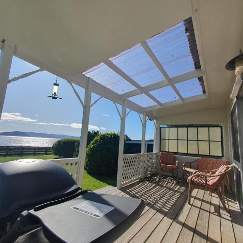 a pergola on a deck with a view of the ocean at Daydream house, Sunrise, sunset views across lake in Rotorua