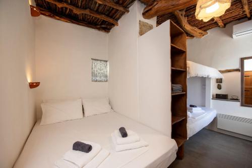 a bedroom with a white bed with towels on it at Giourgas Cottage Milos Island in Ralaki
