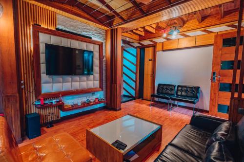 a living room with a couch and a flat screen tv at Millennium Island Residence in Fuvahmulah