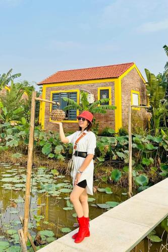 a woman standing on a bridge in front of a house at Ninh Binh Royal Homestay in Ninh Binh