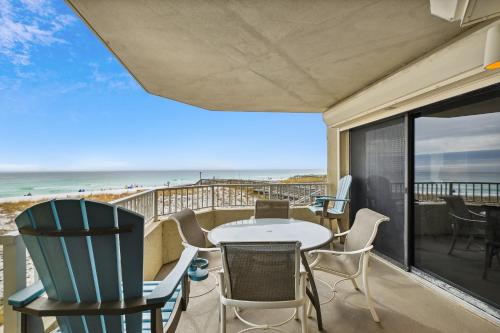 a balcony with a table and chairs and a view of the beach at Inlet Reef 102 Destin Condo in Destin