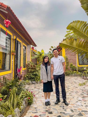 a man and a woman standing in front of a house at Ninh Binh Royal Homestay in Ninh Binh