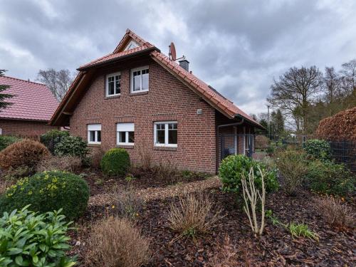 a brick house with a roof in a garden at Ferienhaus Cordes, FeWo Vermittlung Nordsee in Dangastermoor