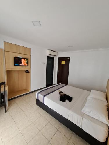 a bedroom with a bed and a tv on a wall at DSH Batu Burok Beach Resort in Kuala Terengganu