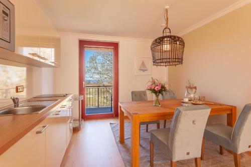 una cucina e una sala da pranzo con tavolo e sedie in legno di HIDDENSEE I mit Ostseeblick Haus Fore a Lohme