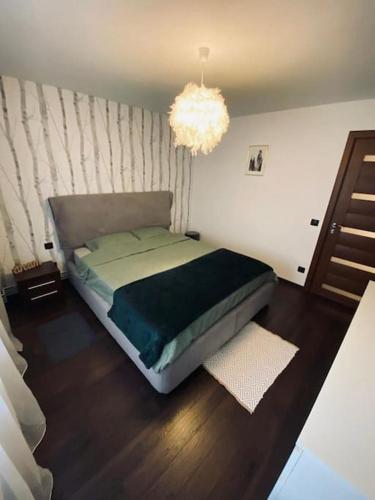 a bedroom with a bed and a chandelier at Aparthotel City Center Targu Ocna in Tîrgu Ocna