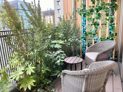 a patio with chairs and plants on a balcony at Dormy Inn Premium Ginza - Natural Hot Spring in Tokyo