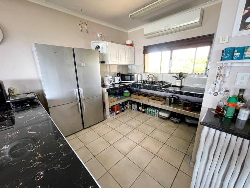 a kitchen with a refrigerator and a tile floor at Kangela 8A in Ponta Malongane