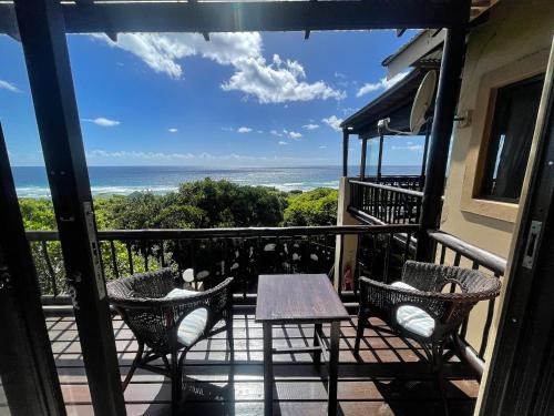 a balcony with a table and chairs and the ocean at Kangela 8A in Ponta Malongane