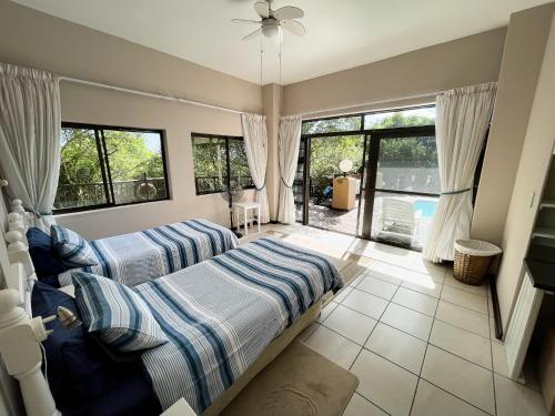 a bedroom with two beds and a large window at Kangela 8A in Ponta Malongane