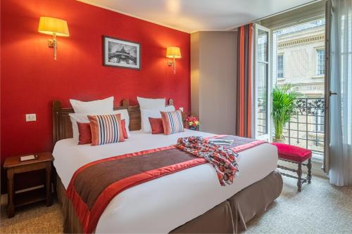 - une chambre avec un grand lit et un mur rouge dans l'établissement Hotel Trianon Rive Gauche, à Paris