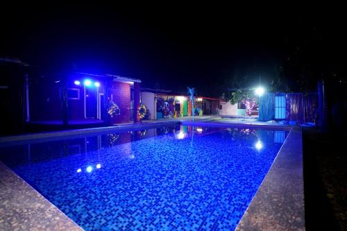 a swimming pool at night with lights on it at Creek Forest - Riverside Boutique Resort in Rishīkesh